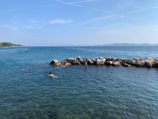 People swimming in the clear Adriatic near the Riva